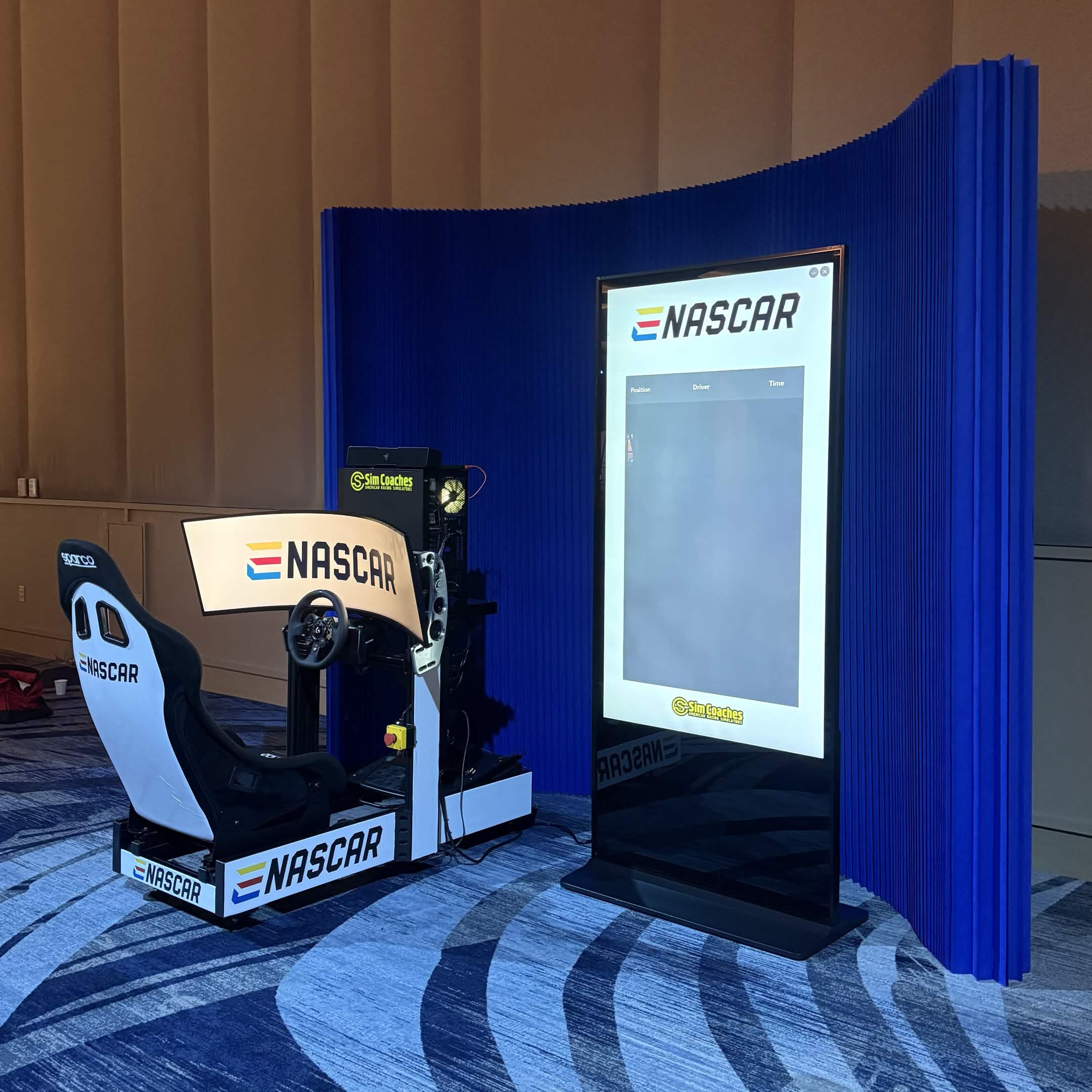 ENASCAR branded simulator setup with curved display and live leaderboard kiosk